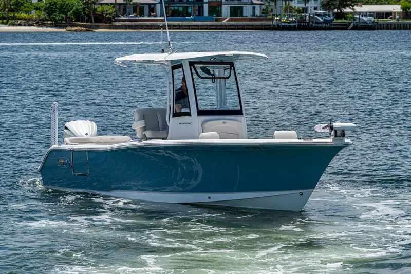 Slide: The Image of 2024 Sea Hunt Ultra 239 SE boat cruising on a calm waterway. - 36