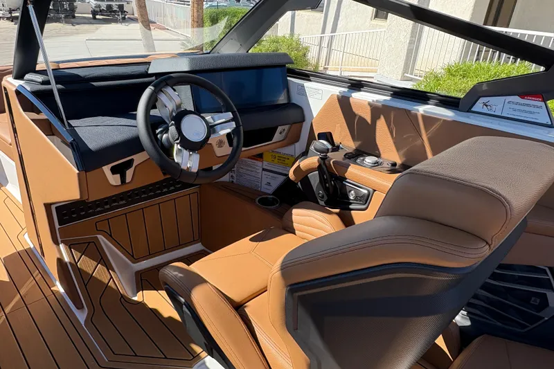 Slide: The Image of 2026 Nautique Super Air Nautique G25 interior with luxurious tan seating and modern dashboard. - 9