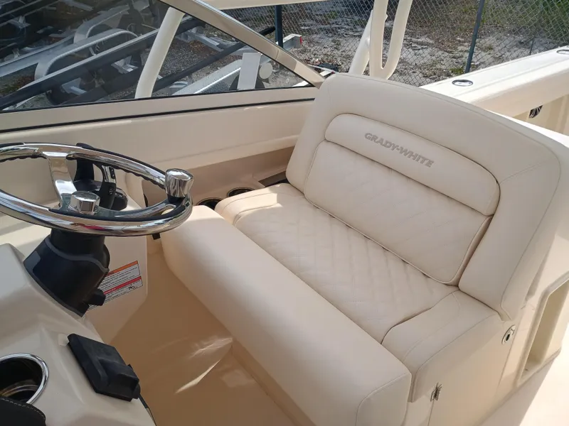 Slide: The Image of 2025 Grady-White Freedom 275 boat interior with steering wheel and cushioned seating. - 12