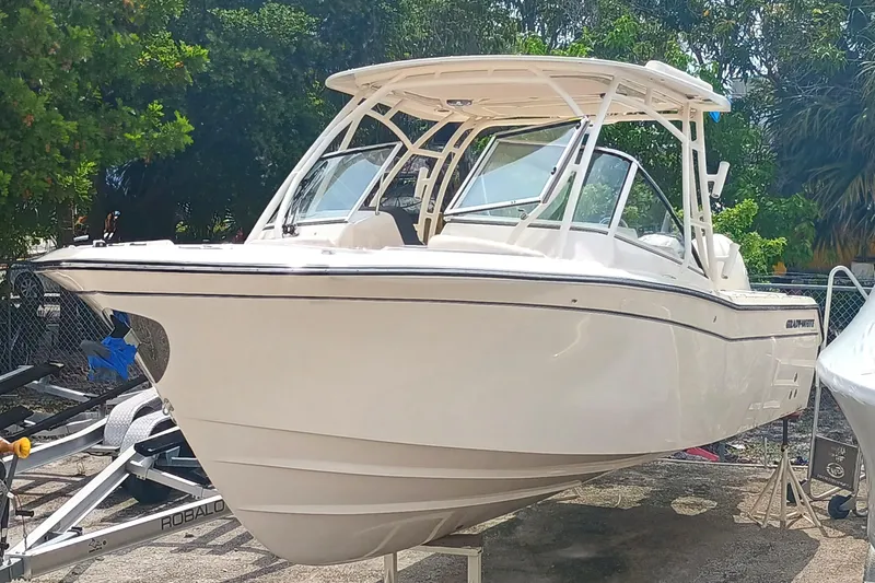 Slide: The Image of 2025 Grady-White Freedom 275 boat on trailer, surrounded by trees. - 3