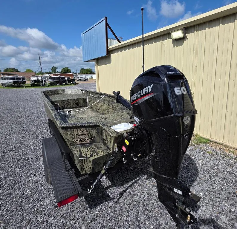 Slide: The Image of 2026 Tracker Grizzly® 1650 T Prairie Wings Edition boat with Mercury 60 engine, parked outdoors. - 2
