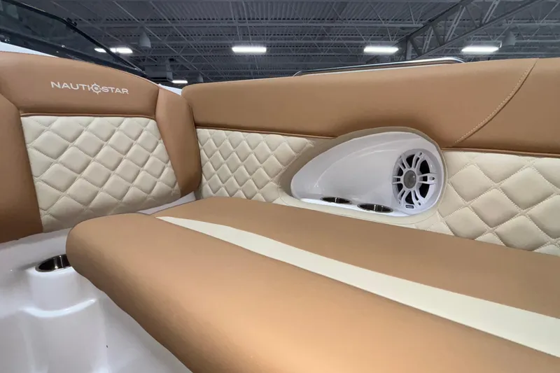 Slide: The Image of Luxurious interior of 2025 NauticStar 243 DC Deck boat with quilted seating and speaker. - 12