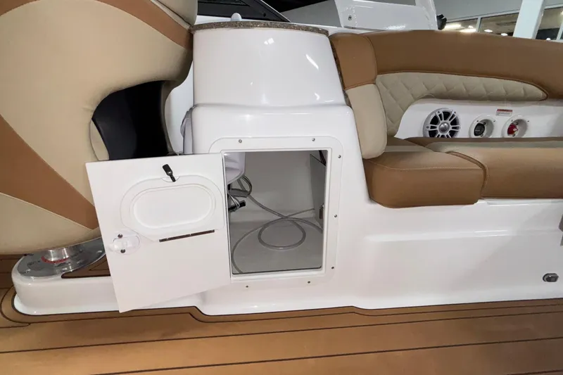 Slide: The Image of 2025 NauticStar 243 DC Deck boat interior with open storage compartment and cushioned seating. - 13