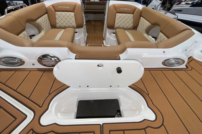 Slide: The Image of 2025 NauticStar 243 DC Deck boat interior with tan seating and storage compartment. - 15