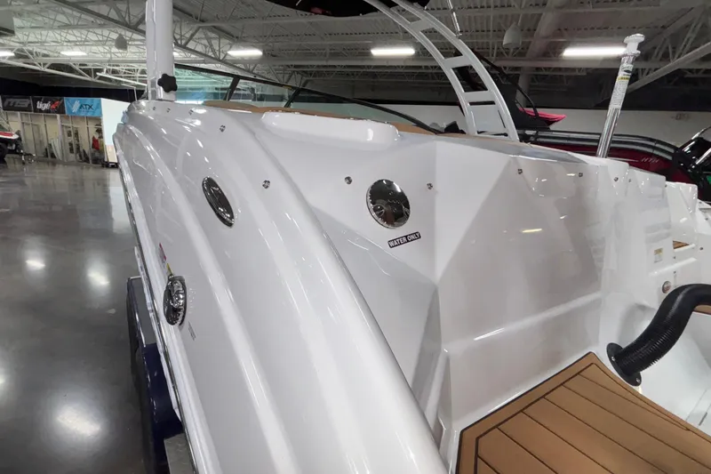 Slide: The Image of 2025 NauticStar 243 DC Deck boat in showroom, showcasing sleek white exterior design. - 21