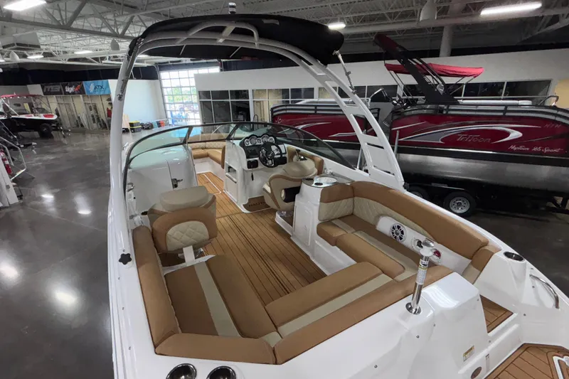 Slide: The Image of 2025 NauticStar 243 DC Deck boat interior with tan seating and modern dashboard. - 23
