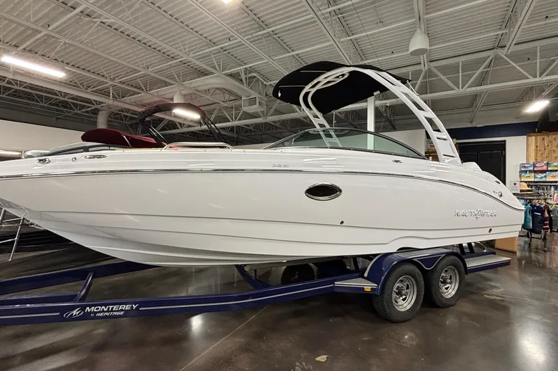 Slide: The Image of 2025 NauticStar 243 DC Deck boat on trailer in showroom. - 26
