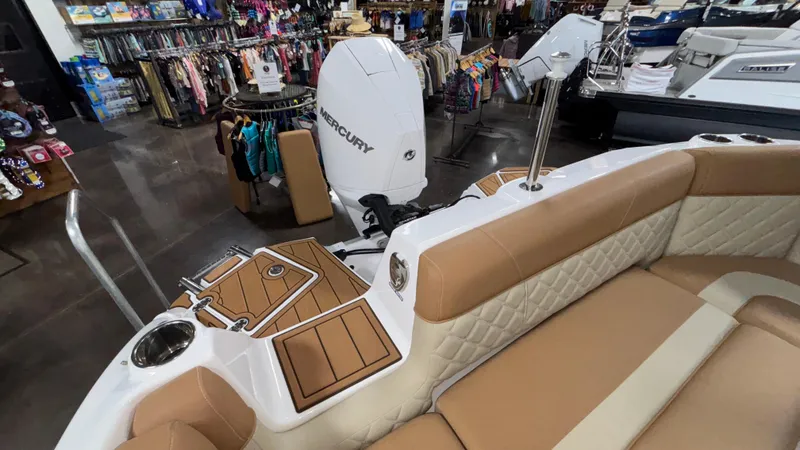 Slide: The Image of 2025 NauticStar 243 DC Deck boat interior with Mercury engine in showroom. - 3