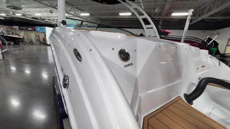 Slide: The Image of 2025 NauticStar 243 DC Deck boat in showroom, showcasing sleek white exterior design. - 5