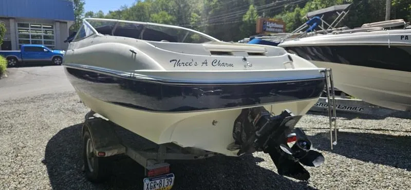 Slide: The Image of 2002 Bayliner 212 Capri Cuddy boat on trailer, parked outdoors. - 3