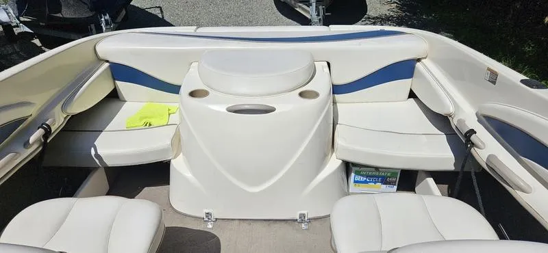 Slide: The Image of 2002 Bayliner 212 Capri Cuddy interior with white seating and storage compartments. - 4