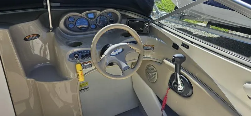 Slide: The Image of 2002 Bayliner 212 Capri Cuddy boat interior with steering wheel and control panel. - 6