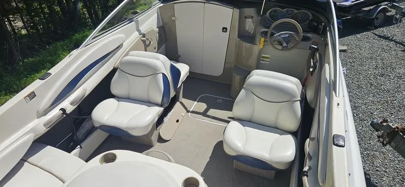 Slide: The Image of 2002 Bayliner 212 Capri Cuddy interior with white seating and steering wheel. - 9