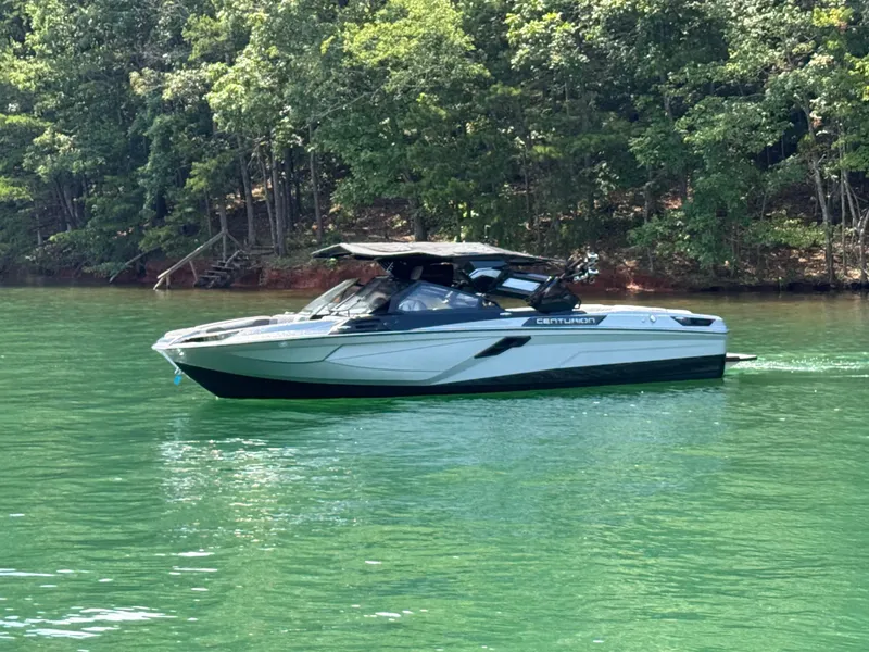 Slide: The Image of 2025 Centurion Ri245 boat on a serene lake with lush green forest backdrop. - 3