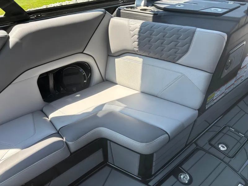 Slide: The Image of 2025 Centurion Ri245 boat interior with gray cushioned seating and speaker. - 6