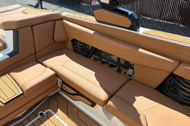 Slide: The Image of 2026 Nautique Super Air Nautique G23 interior with tan leather seating and cup holders. - 11