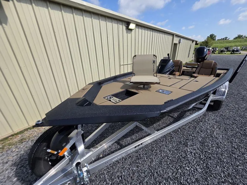 Slide: The Image of 2026 Xpress H20C boat on trailer, parked beside a beige building, under a clear sky. - 14