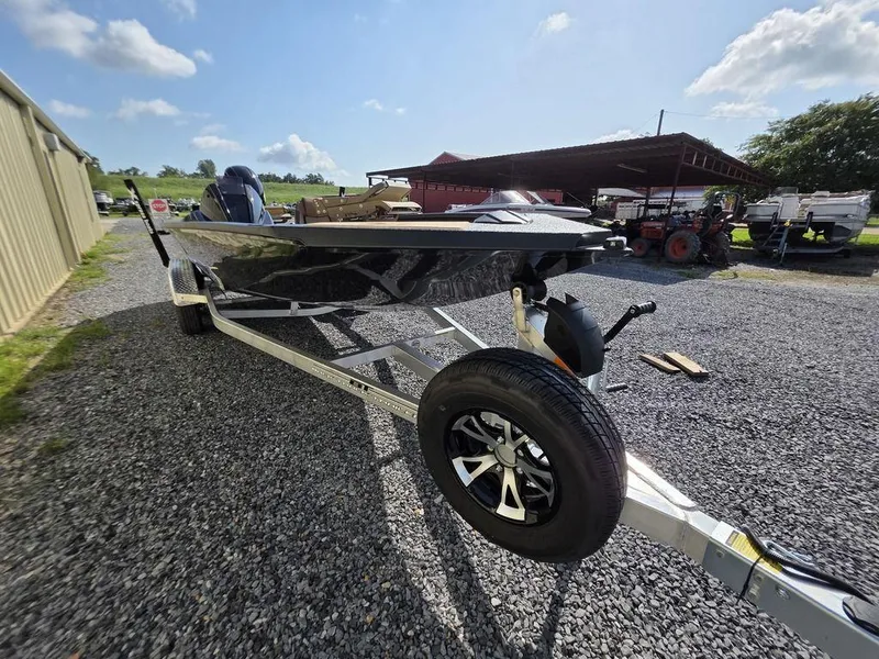 Slide: The Image of 2026 Xpress H20C boat on trailer, parked on gravel, under a clear sky. - 9