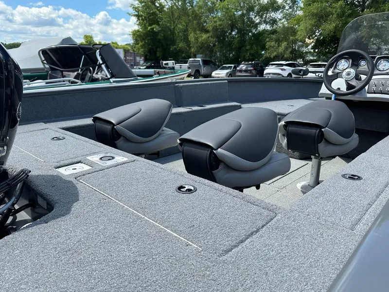 Slide: The Image of 2018 Tracker Pro Guide V-175 SC boat interior with seating and dashboard, under a clear sky. - 15