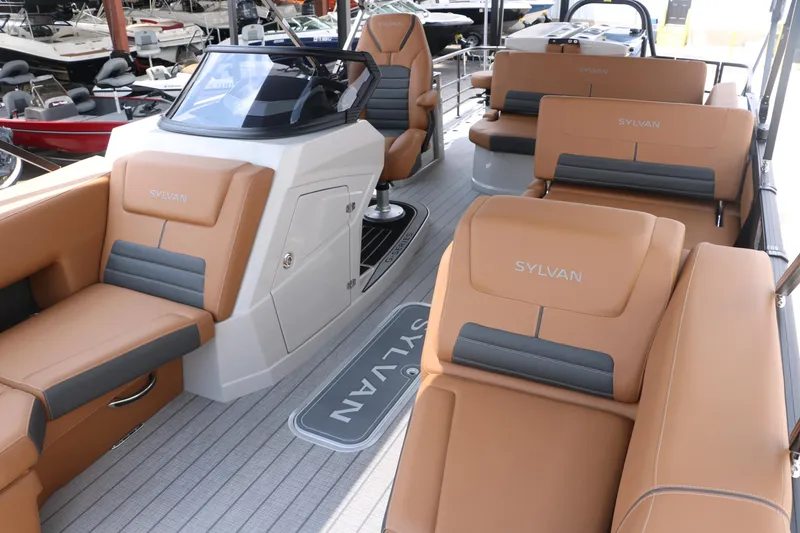 Slide: The Image of 2026 Sylvan G3 DLZ Bar boat interior with tan and gray seating, docked at marina. - 15