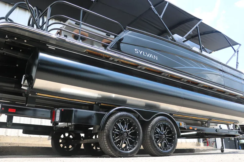Slide: The Image of 2026 Sylvan G3 DLZ Bar pontoon boat on trailer, sleek design, black finish. - 3