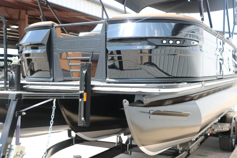 Slide: The Image of 2026 Sylvan G3 DLZ Bar pontoon boat on trailer, sleek black design. - 7