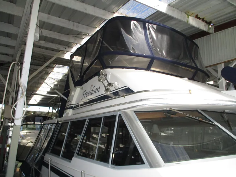 Slide: The Image of 1989 Bayliner 3888 yacht docked in a covered marina. - 10