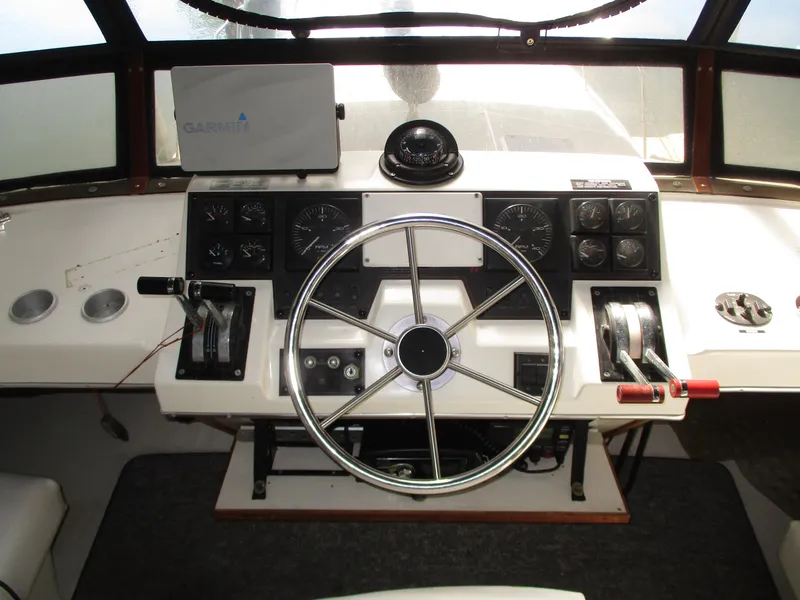 Slide: The Image of 1989 Bayliner 3888 helm with steering wheel, gauges, and Garmin navigation system. - 13