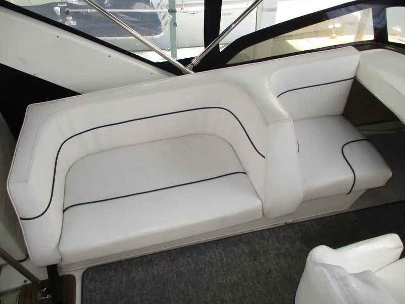 Slide: The Image of White seating area on a 1989 Bayliner 3888 boat, featuring sleek design and comfortable cushions. - 15