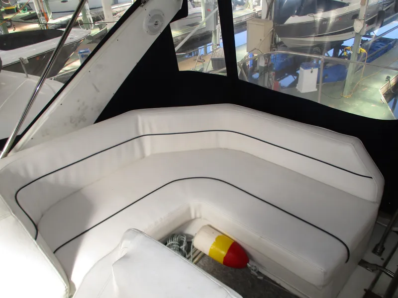 Slide: The Image of 1989 Bayliner 3888 boat interior with white cushioned seating and nautical decor. - 17