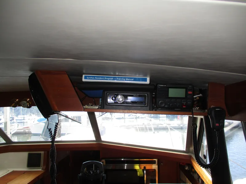 Slide: The Image of 1989 Bayliner 3888 boat interior with radio equipment and manual. - 19