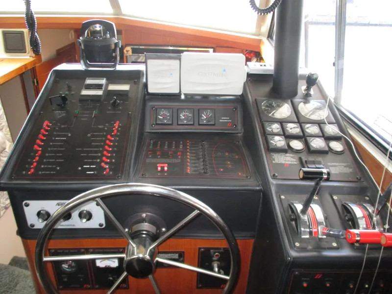Slide: The Image of 1989 Bayliner 3888 helm with steering wheel, gauges, and control panels. - 20