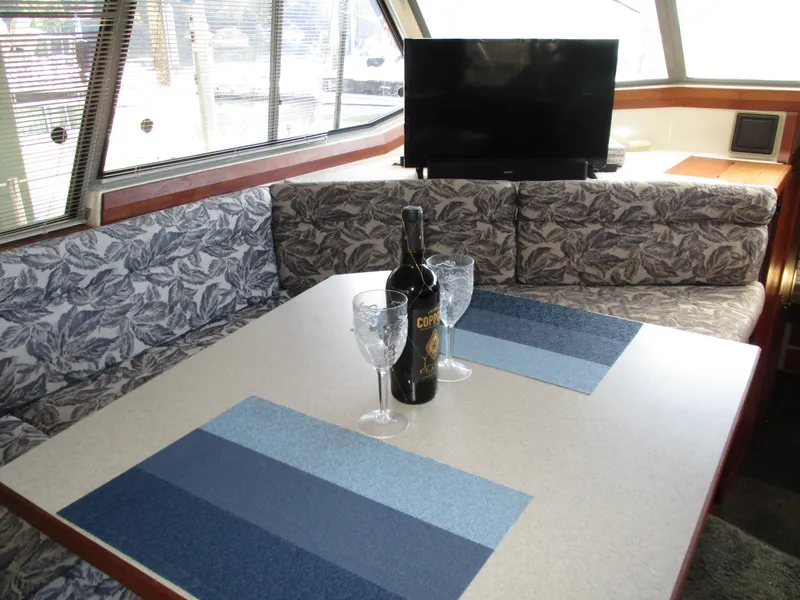 Slide: The Image of Interior of 1989 Bayliner 3888 with dining area, wine bottle, and TV. - 25