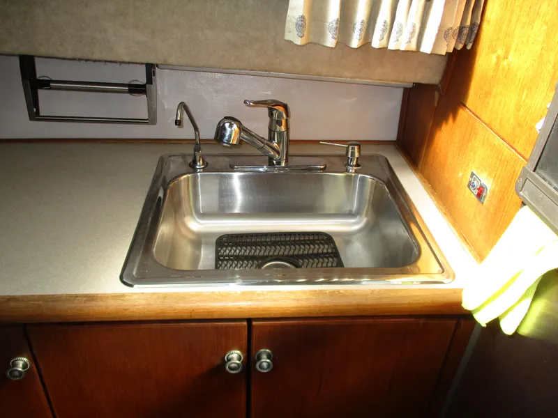 Slide: The Image of Stainless steel sink in 1989 Bayliner 3888 yacht kitchen with wooden cabinets. - 27