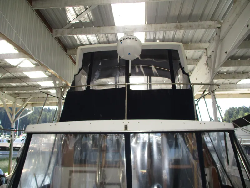 Slide: The Image of 1989 Bayliner 3888 yacht under covered dock, front view with radar equipment. - 3