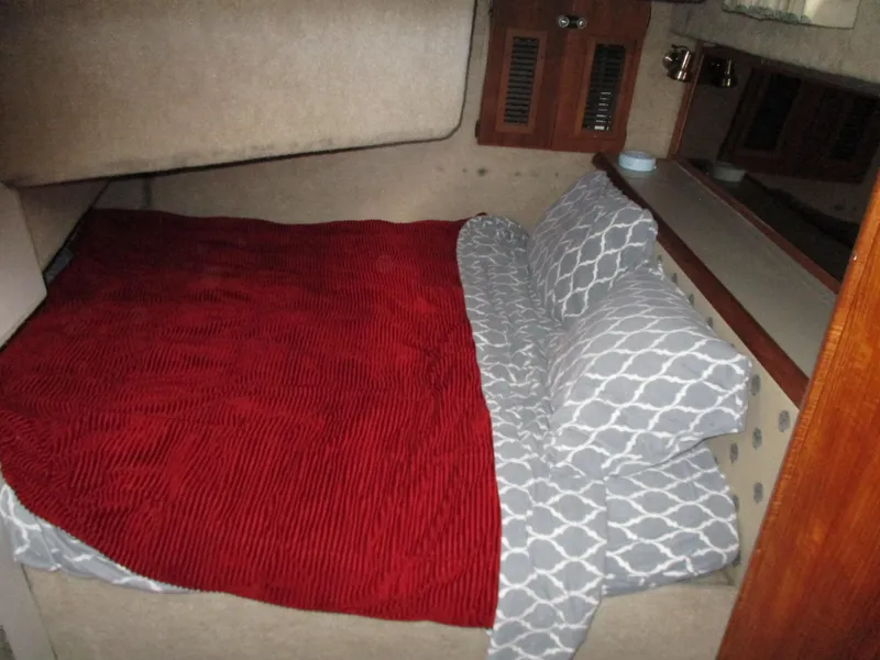 Slide: The Image of Cozy cabin bedroom in 1989 Bayliner 3888 with red blanket and patterned pillows. - 31