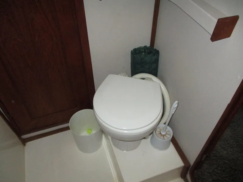 Slide: The Image of 1989 Bayliner 3888 boat bathroom with toilet, wastebasket, and brush. - 33