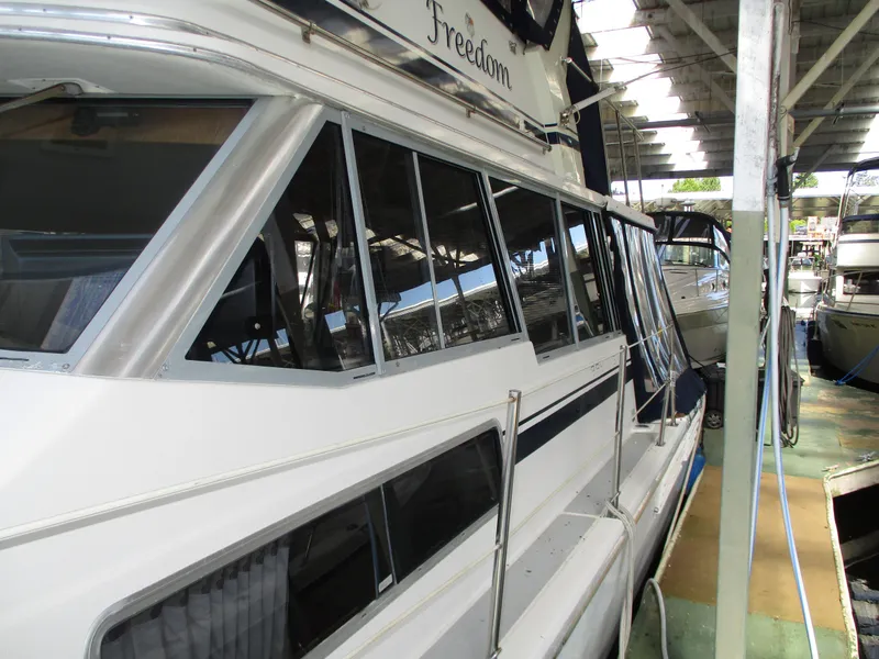 Slide: The Image of 1989 Bayliner 3888 yacht docked in a covered marina, side view. - 4