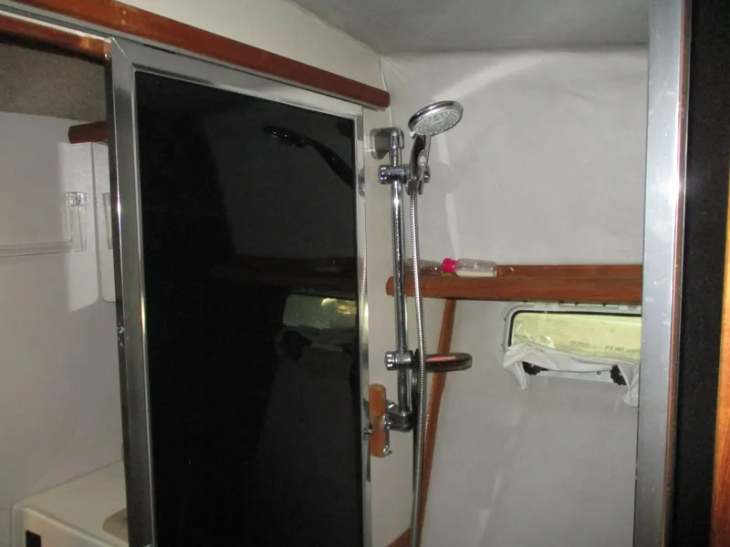Slide: The Image of Shower area inside 1989 Bayliner 3888 boat with window and wooden accents. - 40