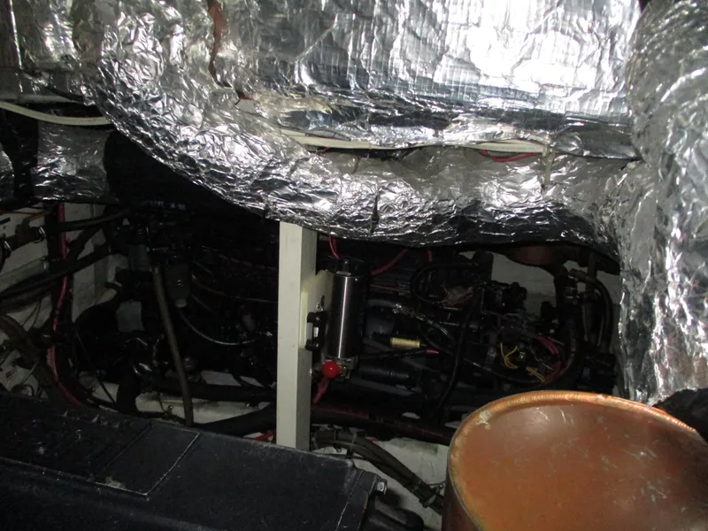 Slide: The Image of Engine room of a 1989 Bayliner 3888, featuring insulated components and mechanical parts. - 42