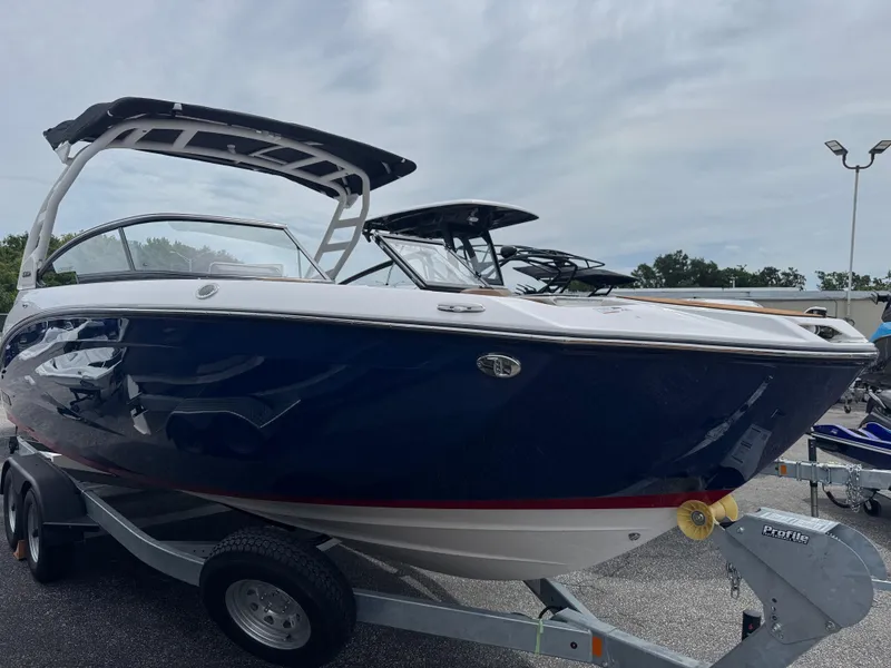 Slide: The Image of 2025 Yamaha Boats 252SD on trailer, sleek design, blue and white exterior. - 1