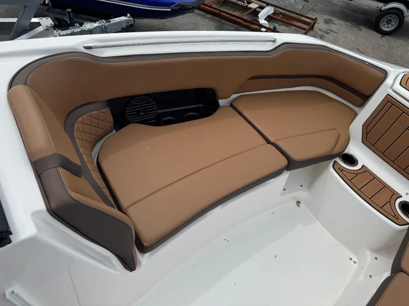 Slide: The Image of Luxurious seating area on 2025 Yamaha Boats 252SD, featuring tan upholstery and cup holders. - 11