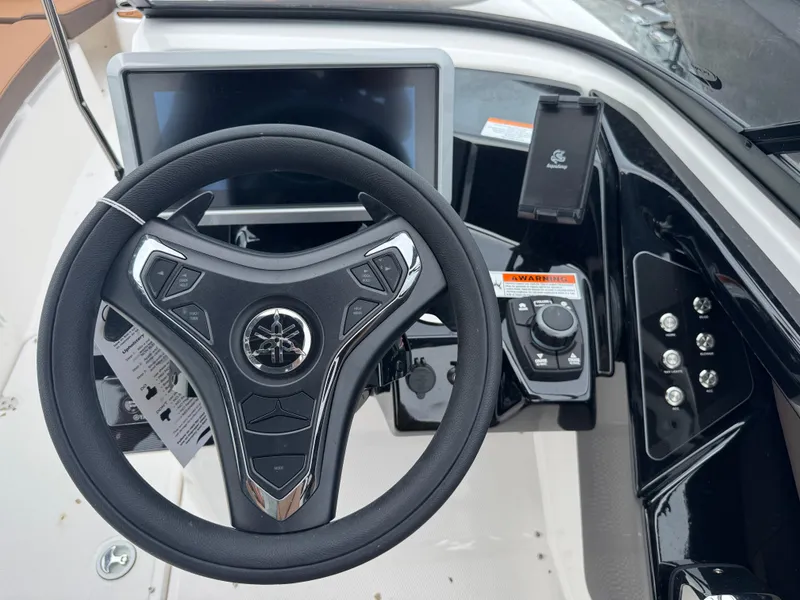 Slide: The Image of 2025 Yamaha Boats 252SD steering wheel and dashboard controls. - 25
