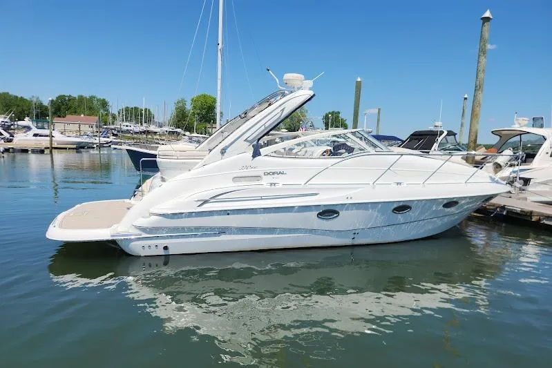 The Image of 2002 Doral 330se boat docked in a marina under clear blue skies. - 0