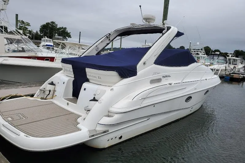Slide: The Image of 2002 Doral 330se boat docked at marina with blue cover. - 1