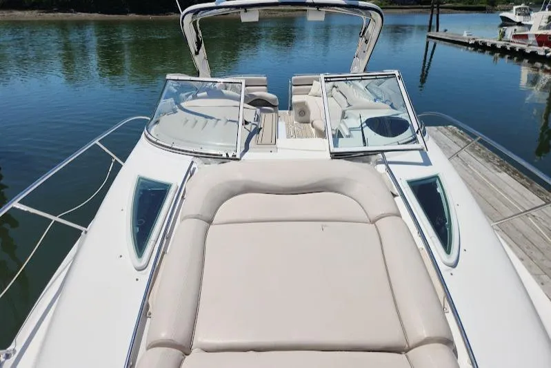 Slide: The Image of 2002 Doral 330se boat with open deck and seating, docked by calm waters. - 12