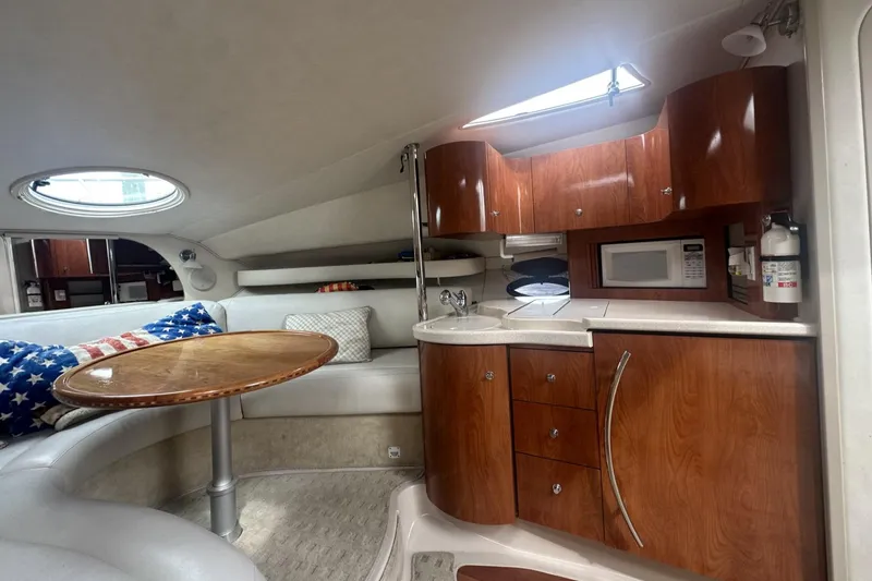 Slide: The Image of Interior of 2002 Doral 330se yacht with wood cabinetry, round table, and kitchenette. - 17