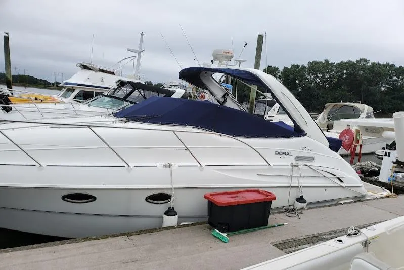 Slide: The Image of 2002 Doral 330se yacht docked at marina with blue canopy. - 2