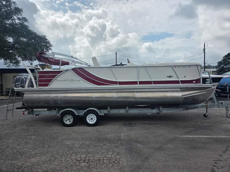 The Image of 2017 South Bay 523 CR pontoon boat on trailer, parked outdoors. - 1