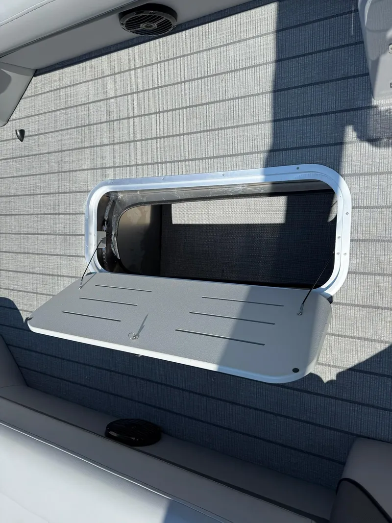 Slide: The Image of 2026 Bentley Pontoons Elite 253 Swingback storage compartment with open hatch on deck. - 12